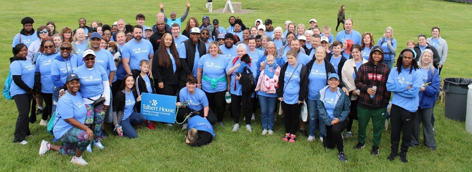 group of people wearing Talbert House shirts in a grass field